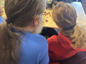 Hacker leert een kind solderen.