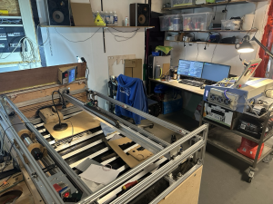 Lasercutter die niet operationeel is en op de achtergrond een aantal computerschermen net code erop.