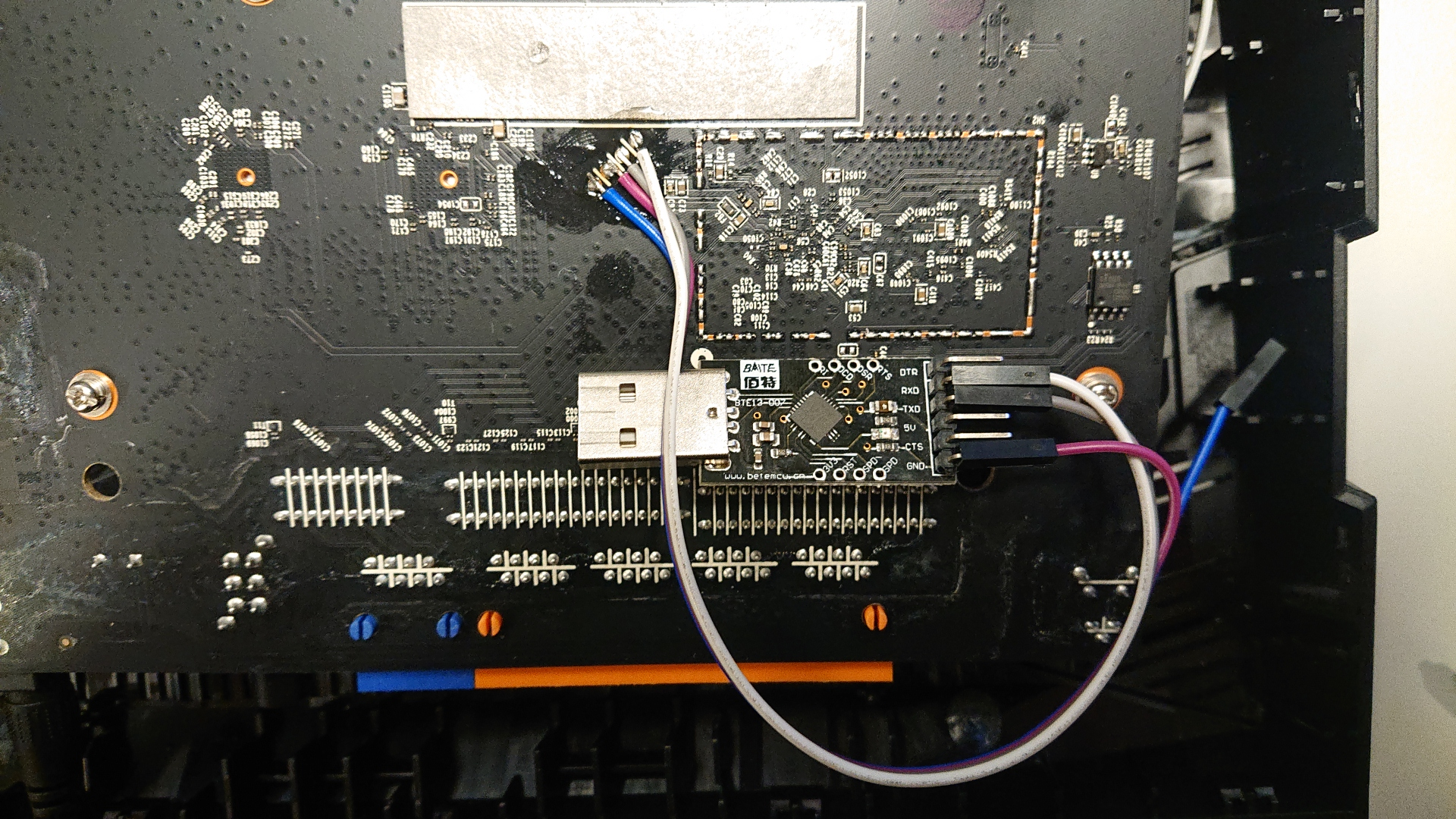 De printplaat van de AX23, met draadjes aan de seriele verbinding gesoldeerd en een USB-serial converter